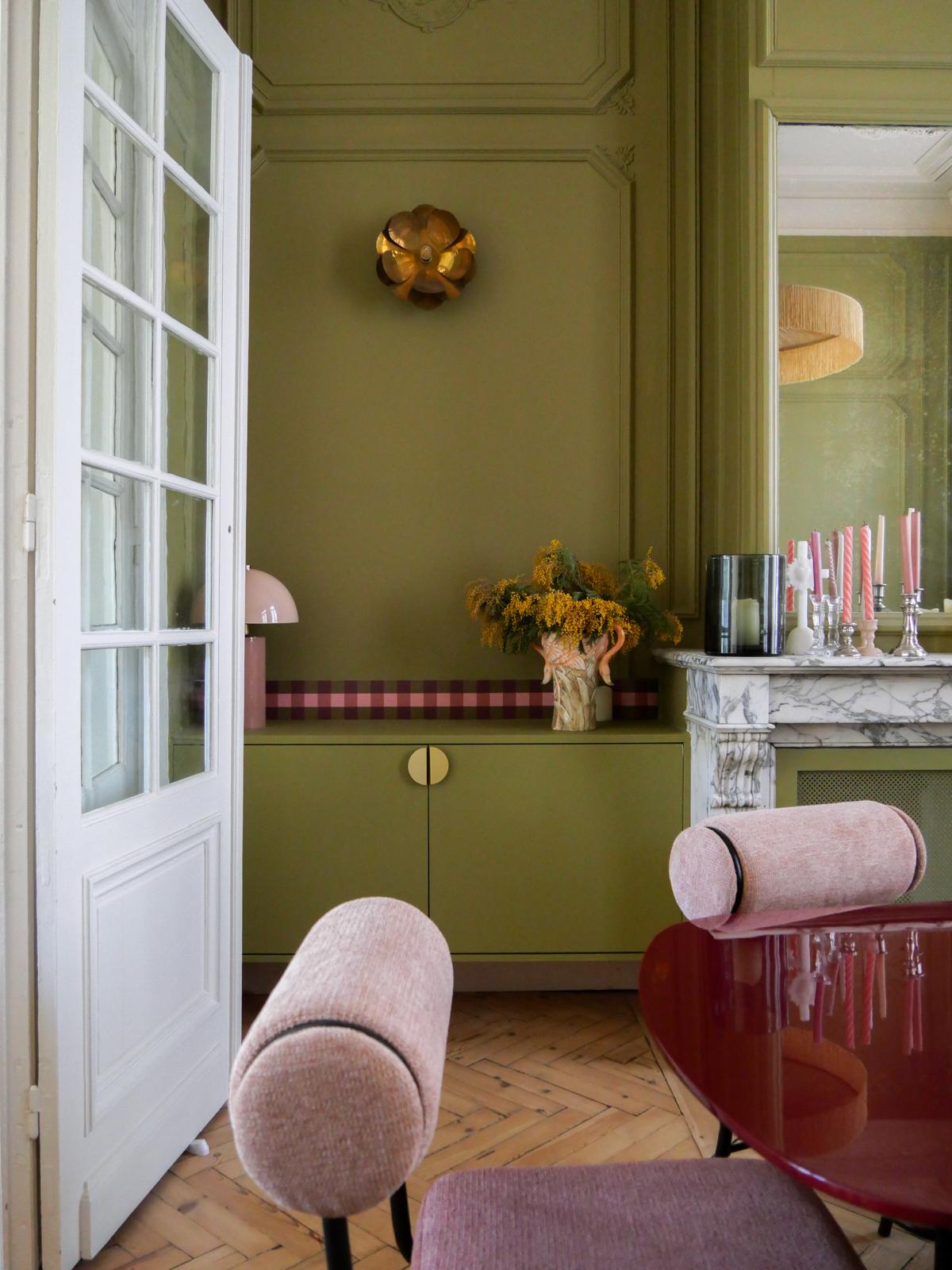 Frise Cadence Bordeaux posée en bandeau mural dans un salon haussmannien vert olive — cheminée marbre, fauteuils rose poudré Bilboquet Déco
