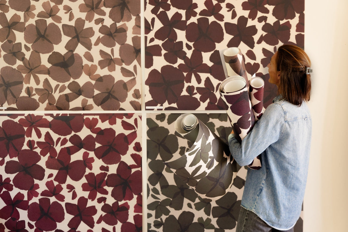 Les Commères au mur en quatre coloris, rouleaux de papier peint dans les bras