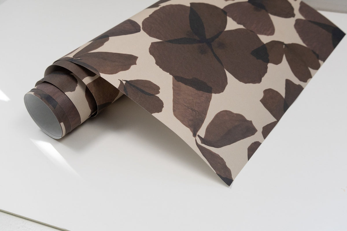 Papier peint Les Commères Tabac en rouleau, motif de fleurs d'hortensia sur fond greige