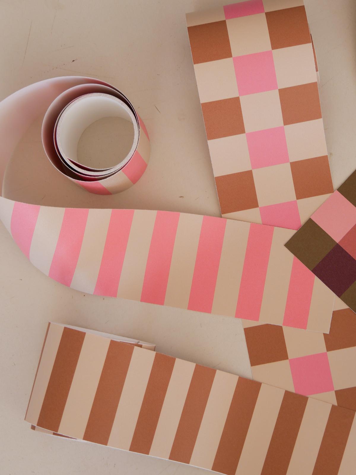Rouleau de la frise Cadence Rose déroulé aux côtés des autres frises de la collection, teintes camel, rose et crème — Bilboquet Déco