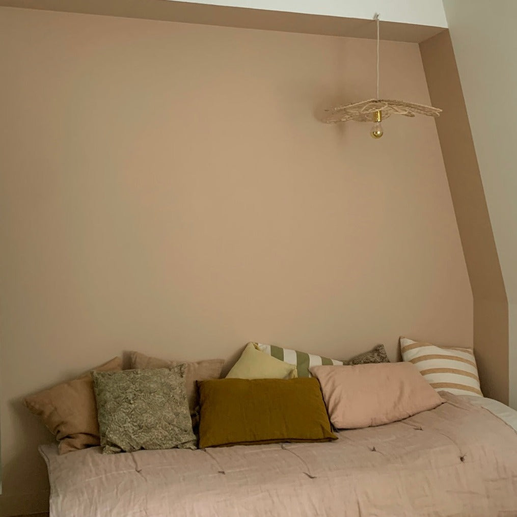Chambre aux murs Mimi cracra de Bilboquet Deco, beige rosé avec lit et coussins colorés