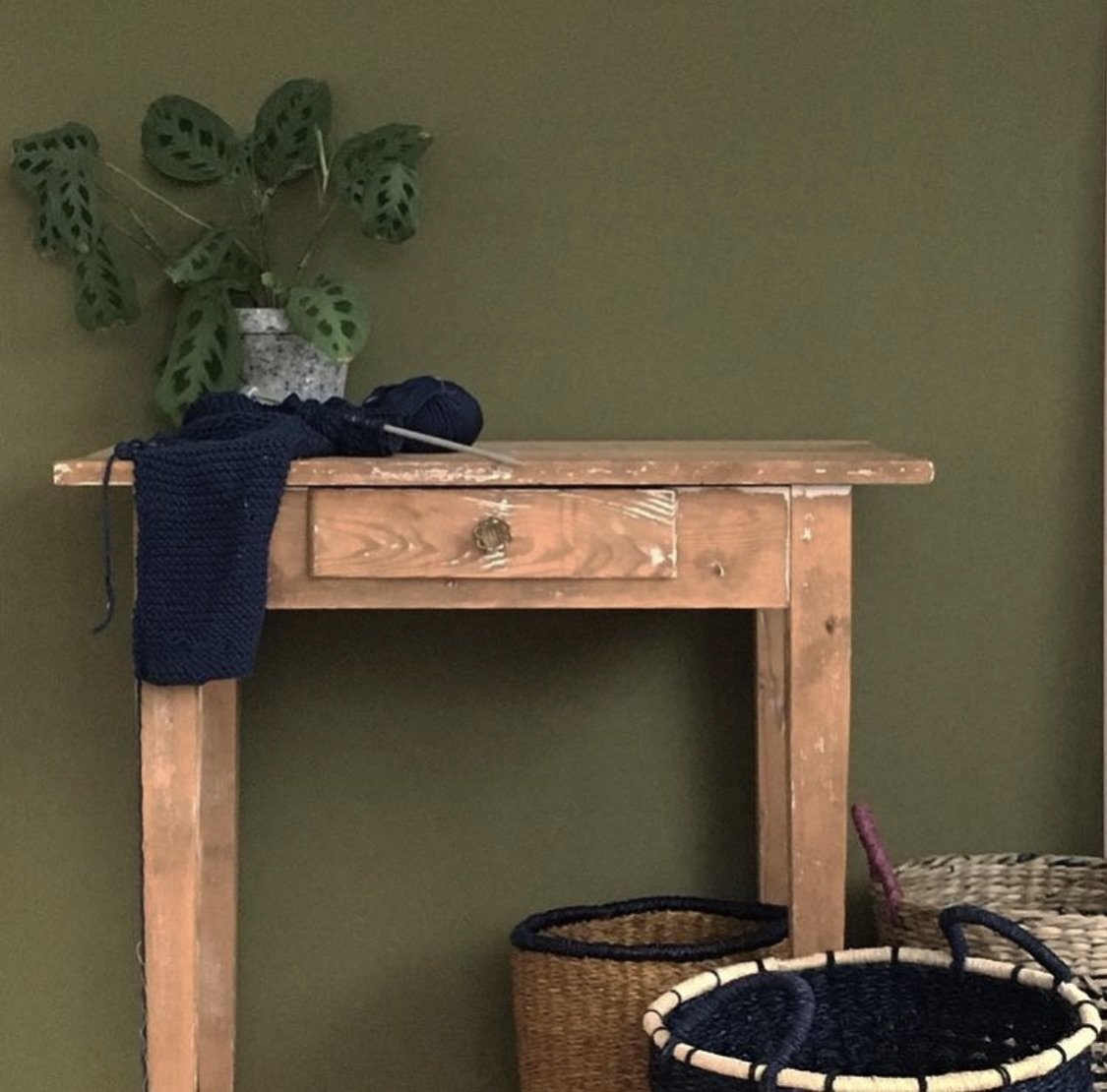 Intérieur aux murs Classe verte de Bilboquet Deco, vert olive avec table ancienne et paniers en osier