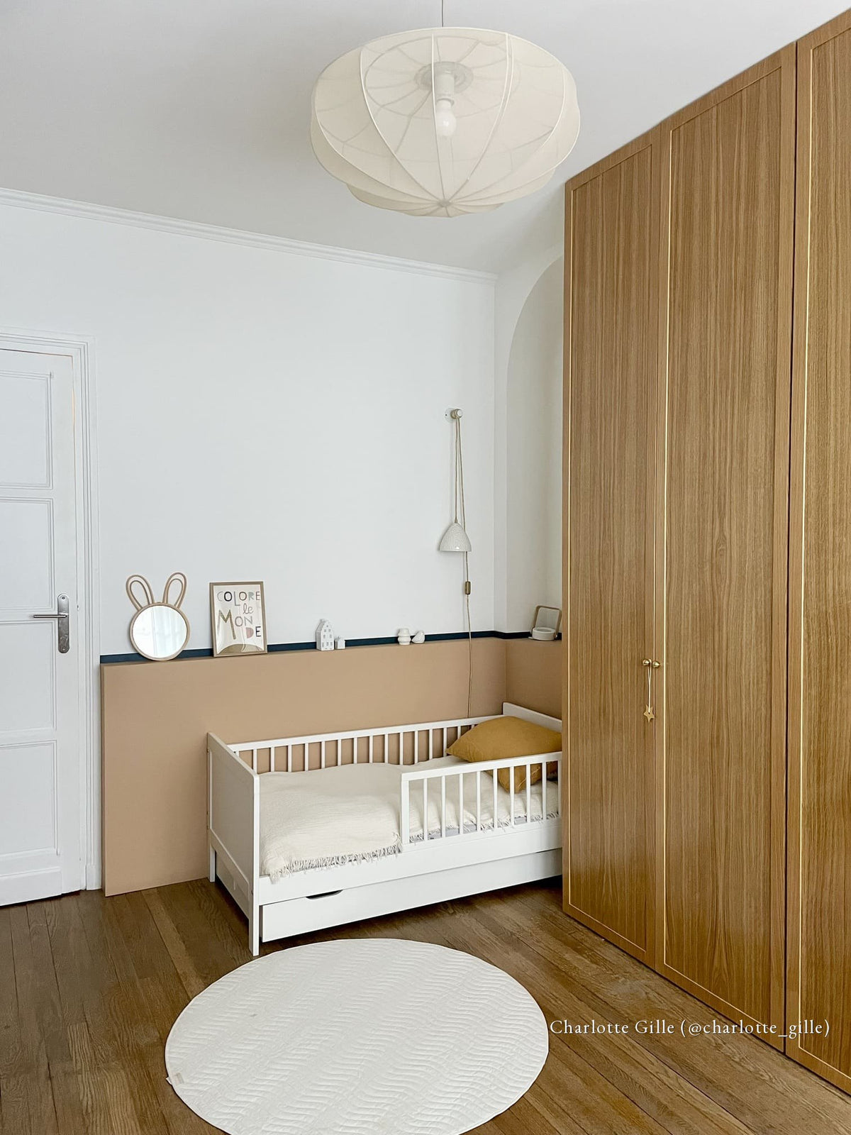 Chambre d'enfant avec soubassement peint en Tête Brûlée Bilboquet Déco et liseré noir, lit blanc et dressing en chêne
